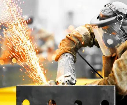 Funcionário cortando aço com serra